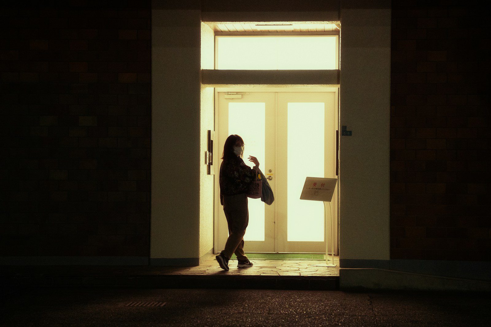 Persona davanti alla porta di casa dopo la decisione di lasciare l’abitazione coniugale